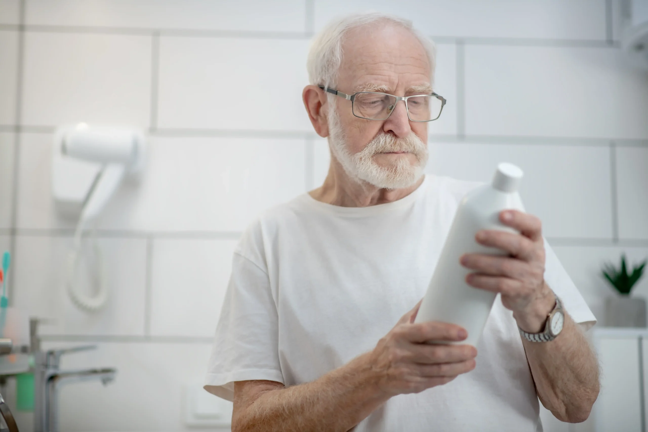 new-shampoo-gray-haired-man-eyeglasses-scrutinizing-bottle-shampoo